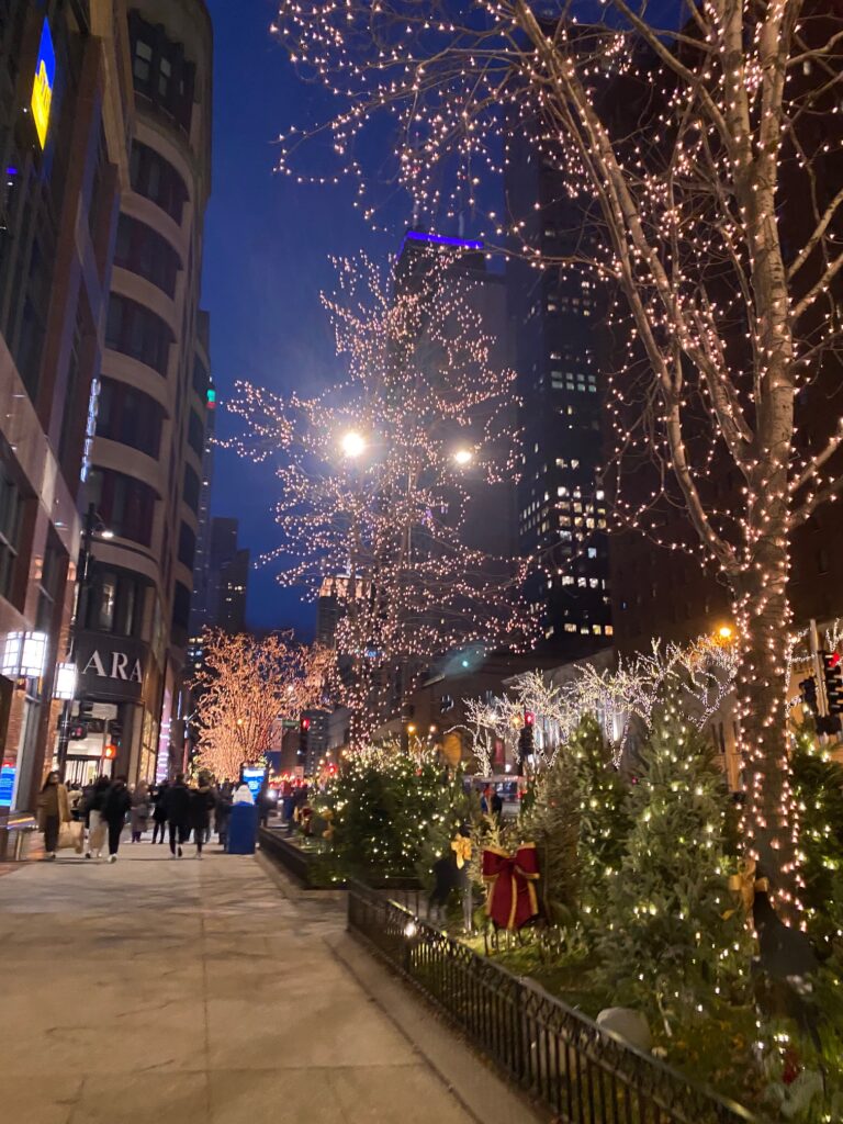 Downtown Chicago sidewalk at night with twinkle lights and lit buildings
