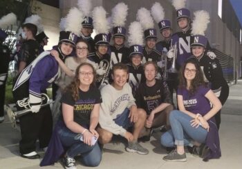 14 members of Northwestern's mellophone section in band uniforms or NU t-shirts