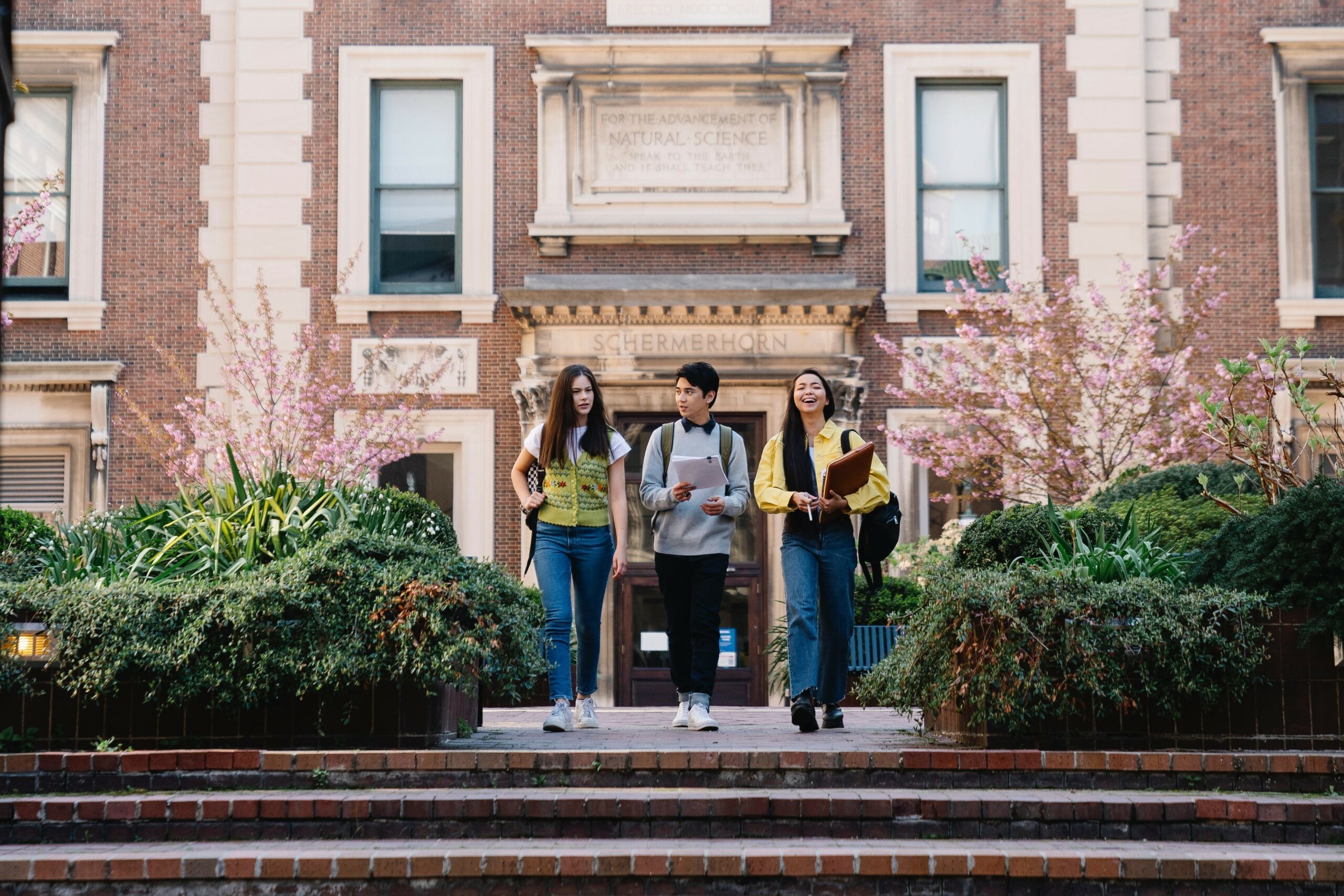 Three students walking outside science building