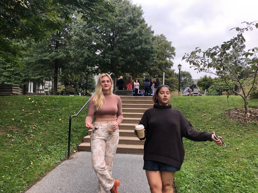 Two female tour guides at Swarthmore walking down sidewalk
