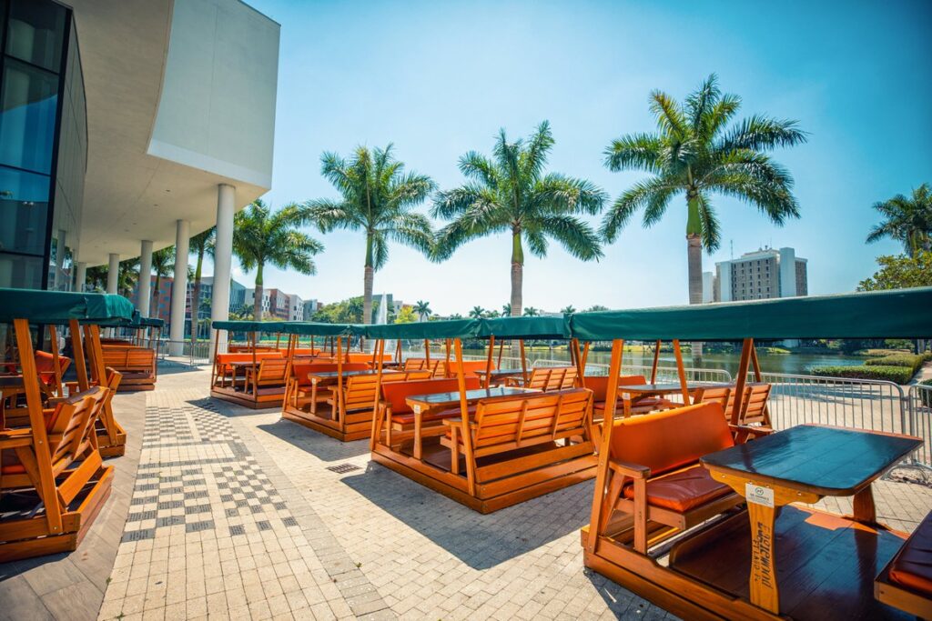 Campus restaurant seating along waterway lined with palm trees