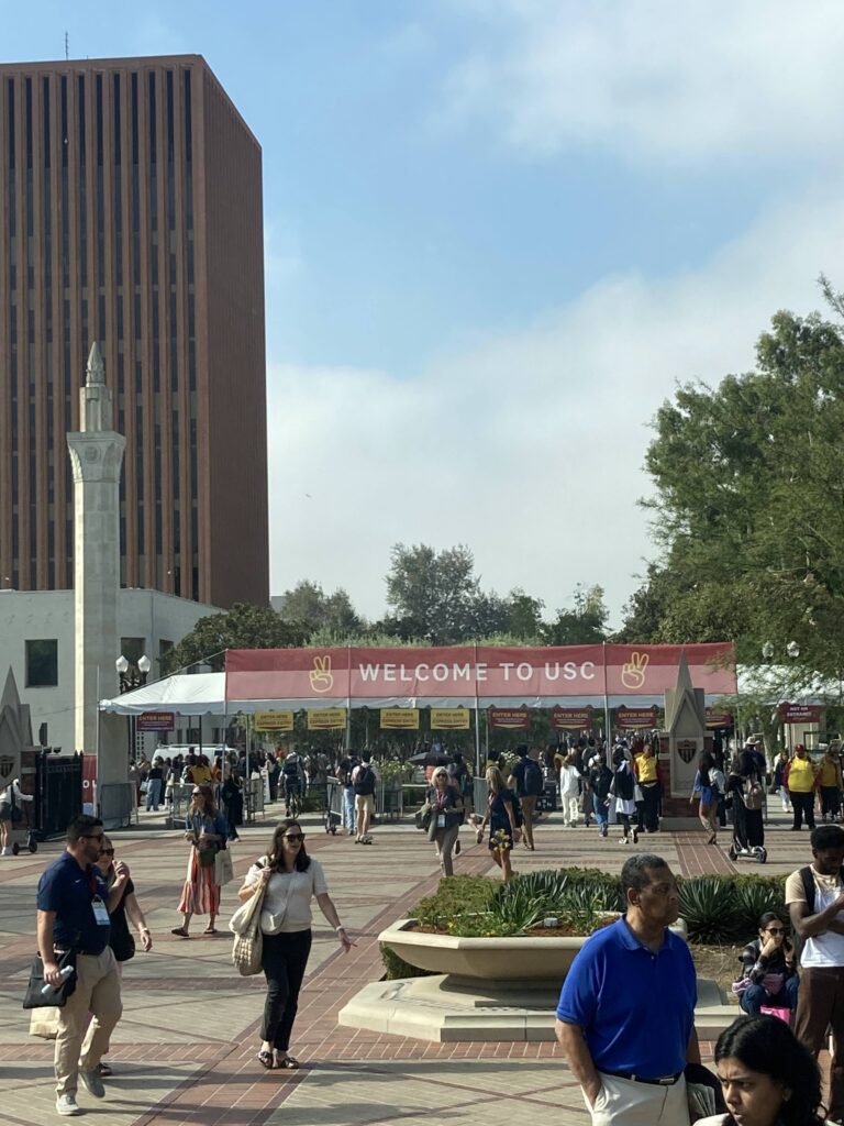 Students entering campus under red Welcome to USC banner